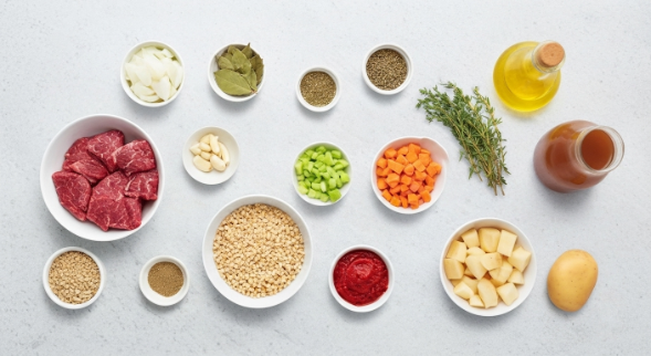 Flat lay of ingredients for beef and barley soup with root vegetables