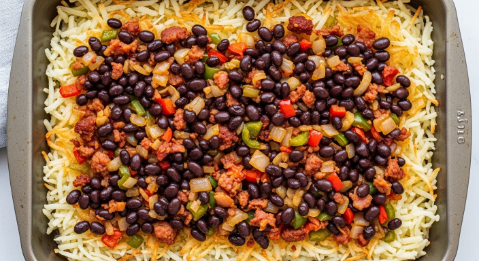 Layering hash browns, sausage-veg mix, and black beans in baking dish