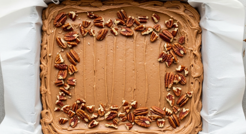 spreading maple pecan fudge into parchment lined pan