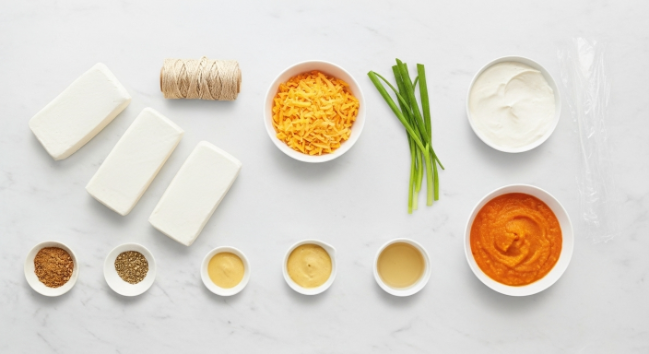 Ingredients for pumpkin cheese ball arranged on board