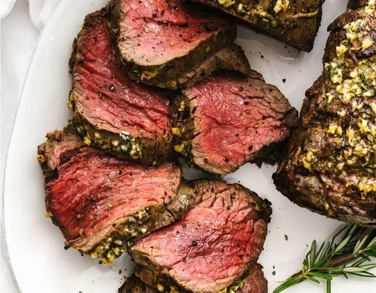 Juicy Beef Tenderloin Roast served with fresh herbs and sides