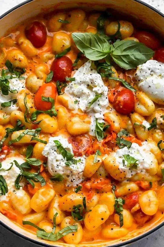 Bowl of creamy tomato gnocchi served with basil