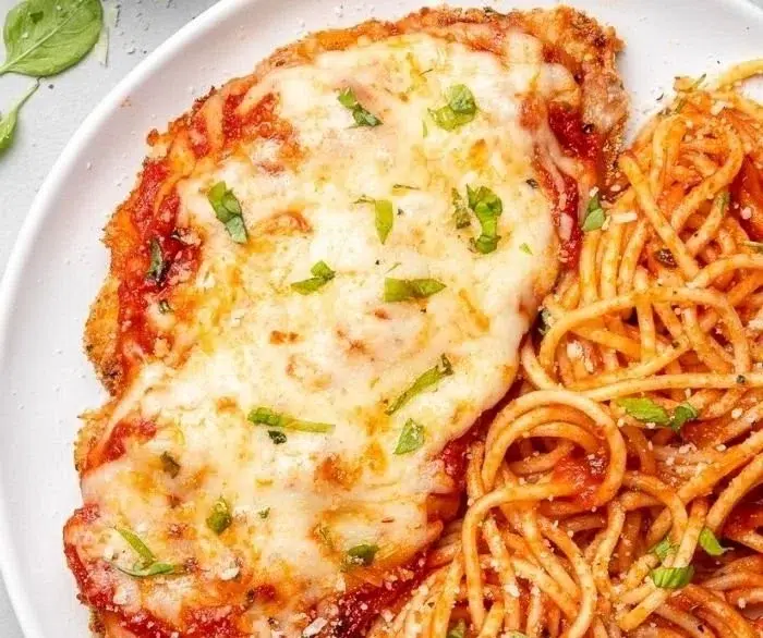 Baked Chicken Parmesan served on a plate with tomato sauce and cheese
