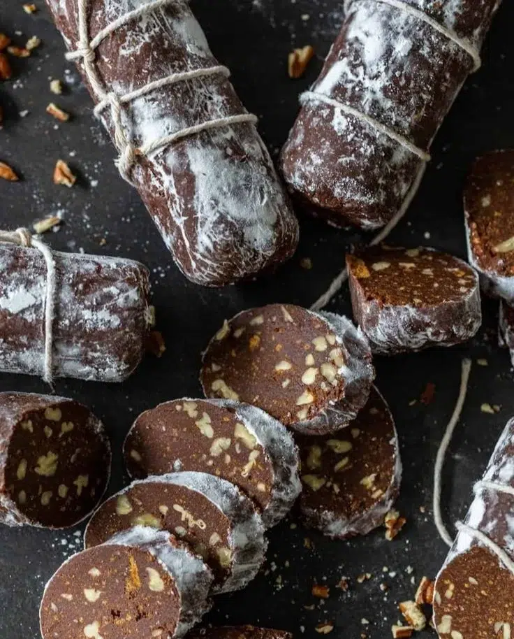 Delicious Chocolate Salami sliced on a wooden board, showcasing its rich chocolate layers