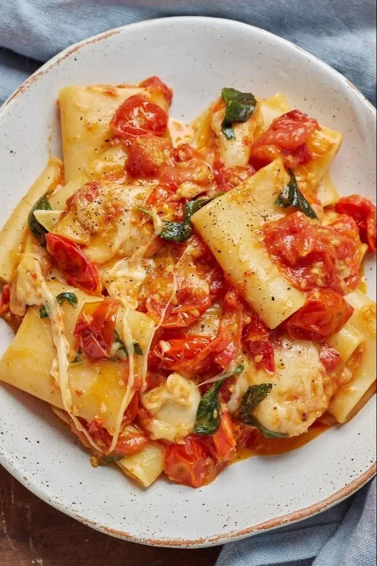 Sorrento-style pasta dish garnished with fresh herbs and tomatoes