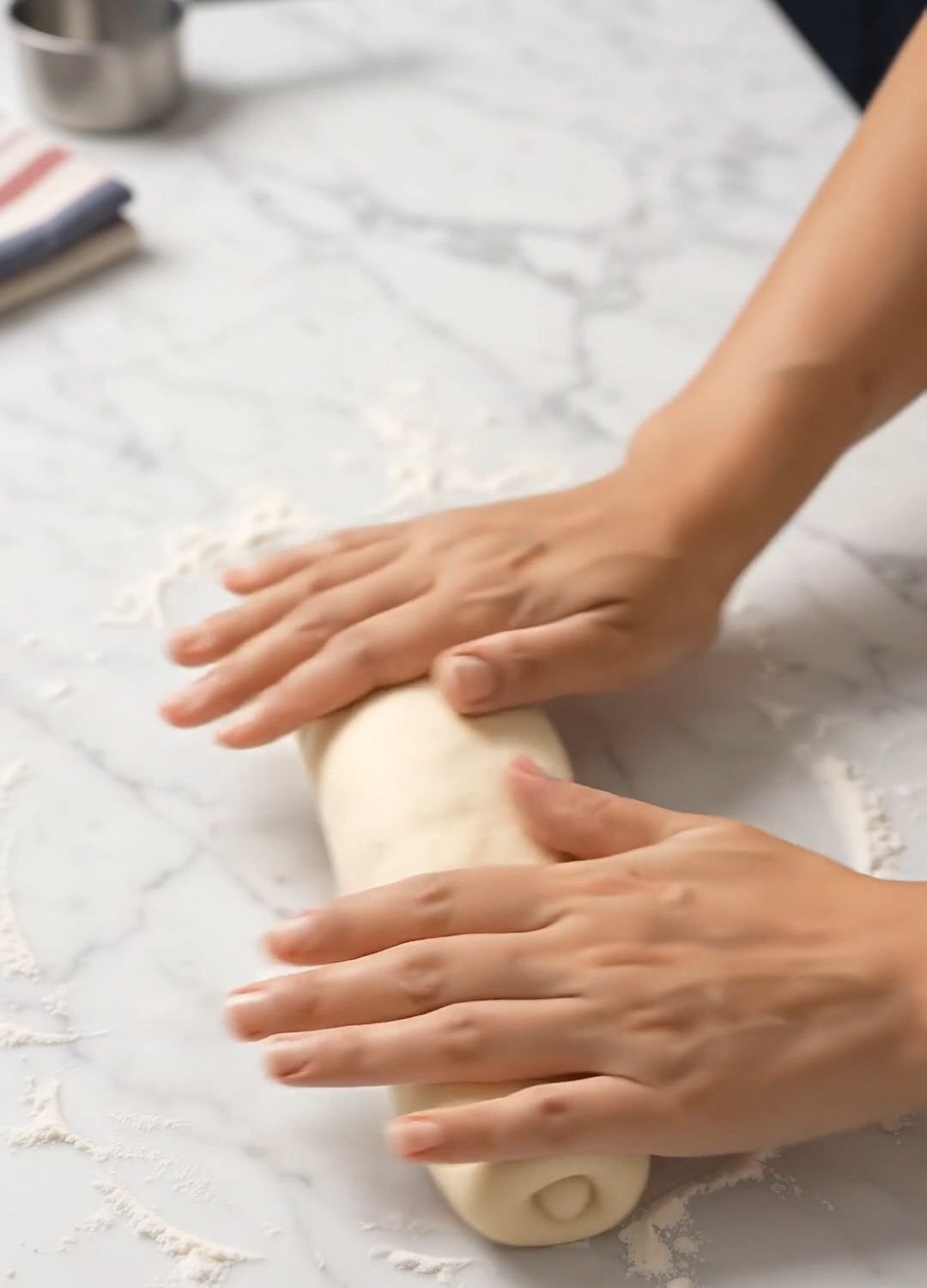 Rolling bread dough into a long oval for the dachshund body
